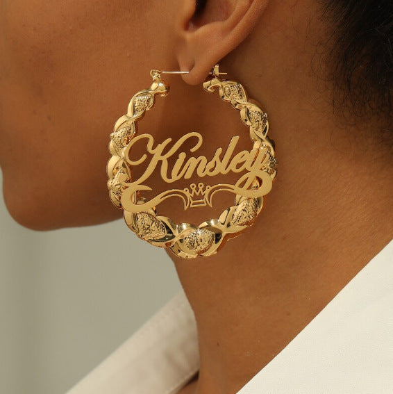 Gold name hoop earring worn on ear