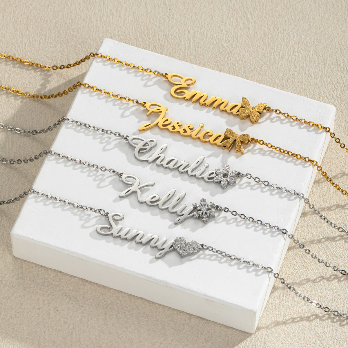 Five name necklaces with different charm accents