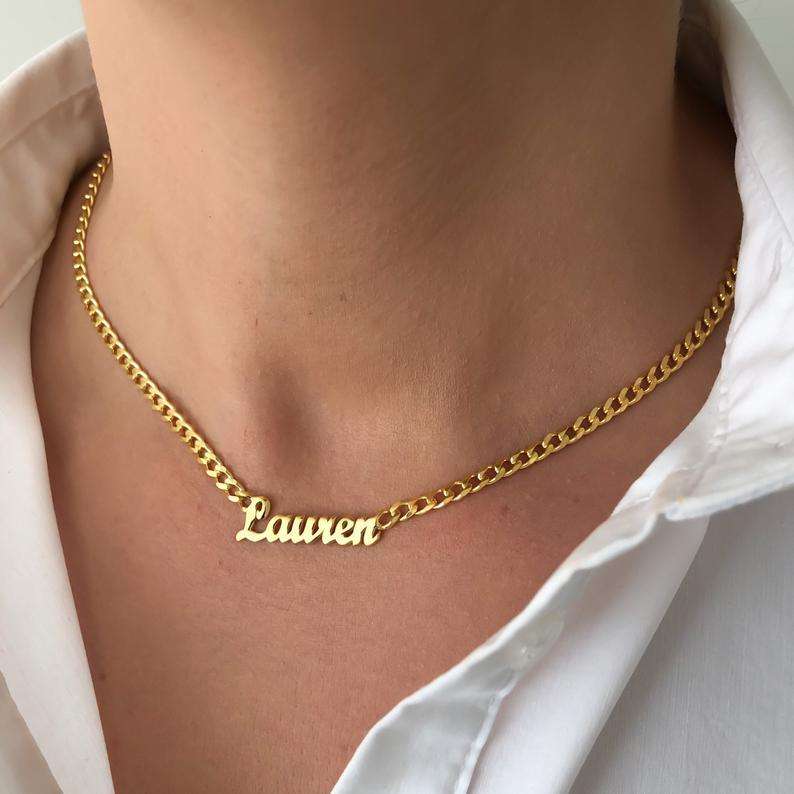 Model wearing gold Cuban chain necklace with custom name pendant