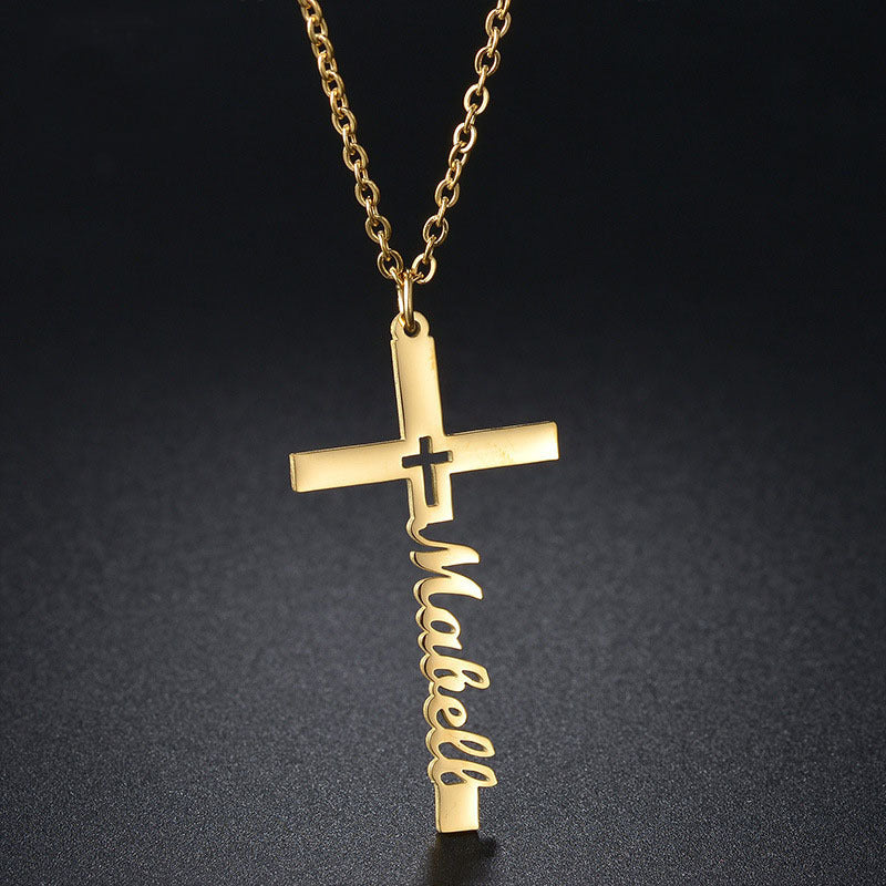 Close-up of gold cross necklace with name pendant