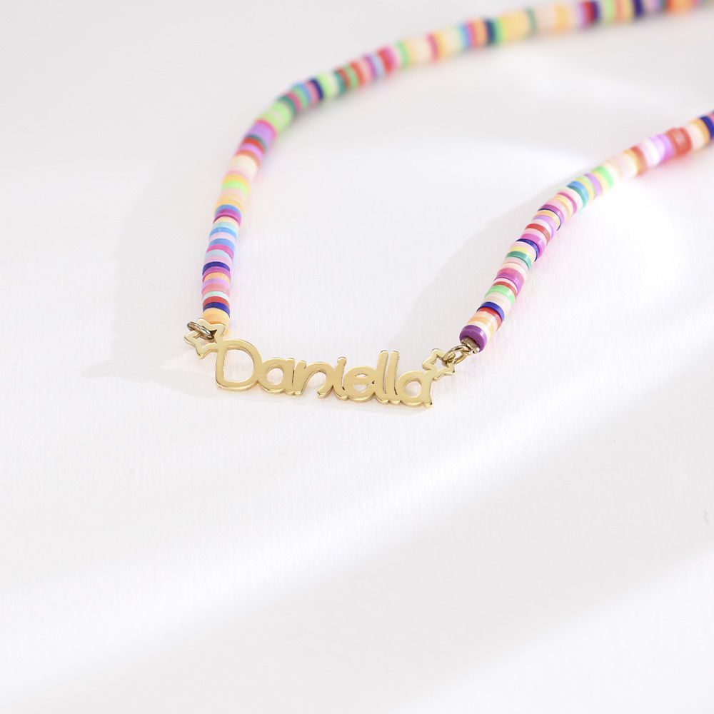 Close-up of gold nameplate on rainbow clay bead necklace