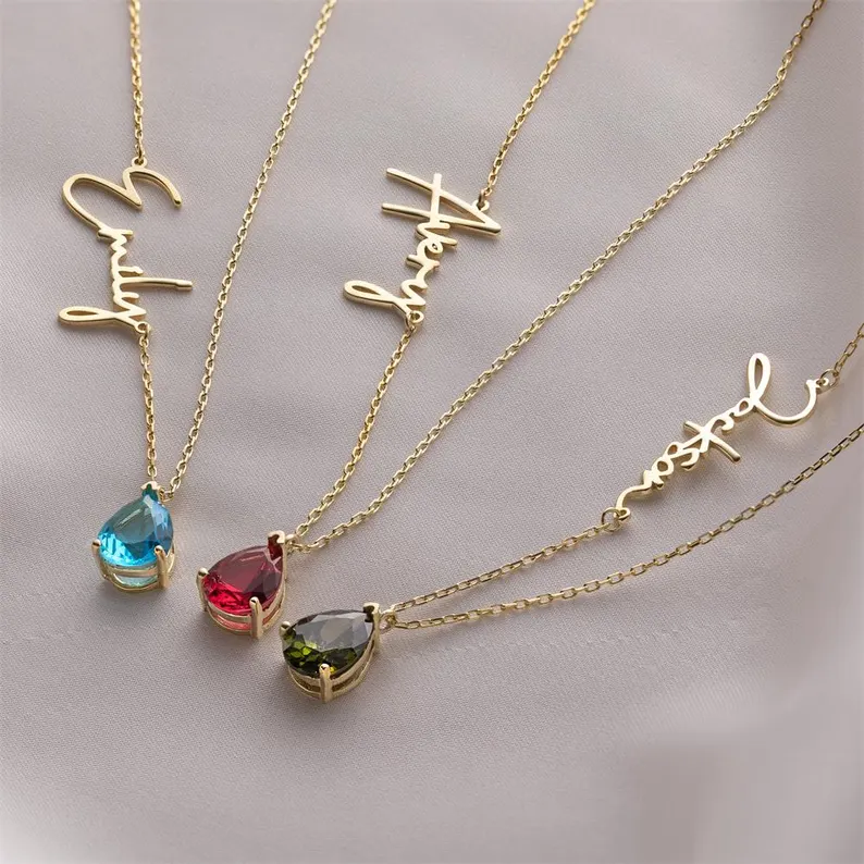 Four gold name necklaces with different colored teardrop birthstones