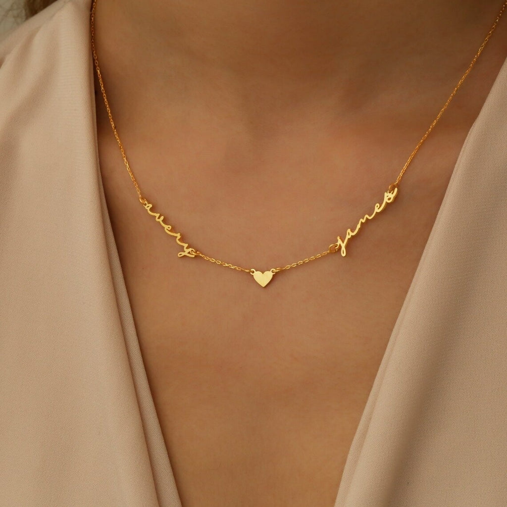 Model wearing gold two-name necklace with heart charm