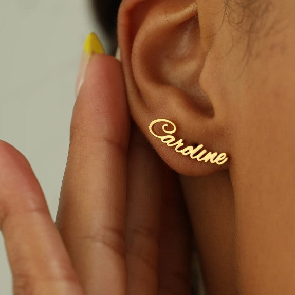 Gold cursive name stud earring worn on ear
