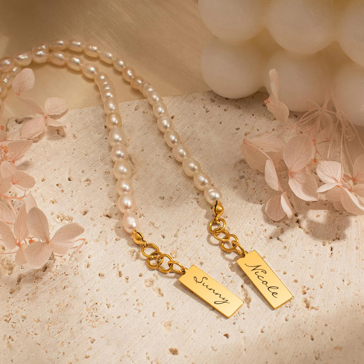 Two pearl bracelets with gold engraved name tags