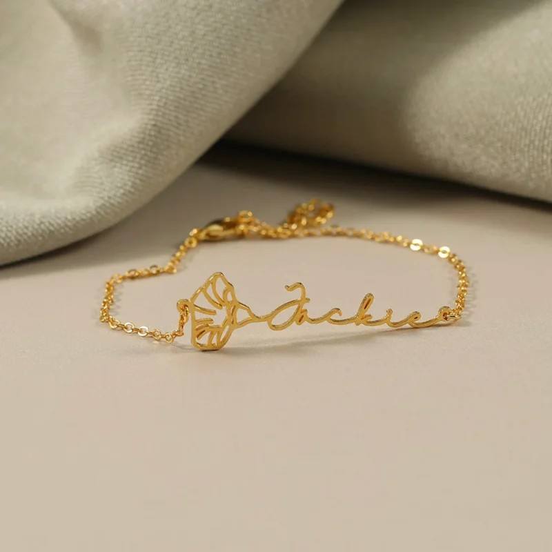 Gold flower vine name bracelet flat lay